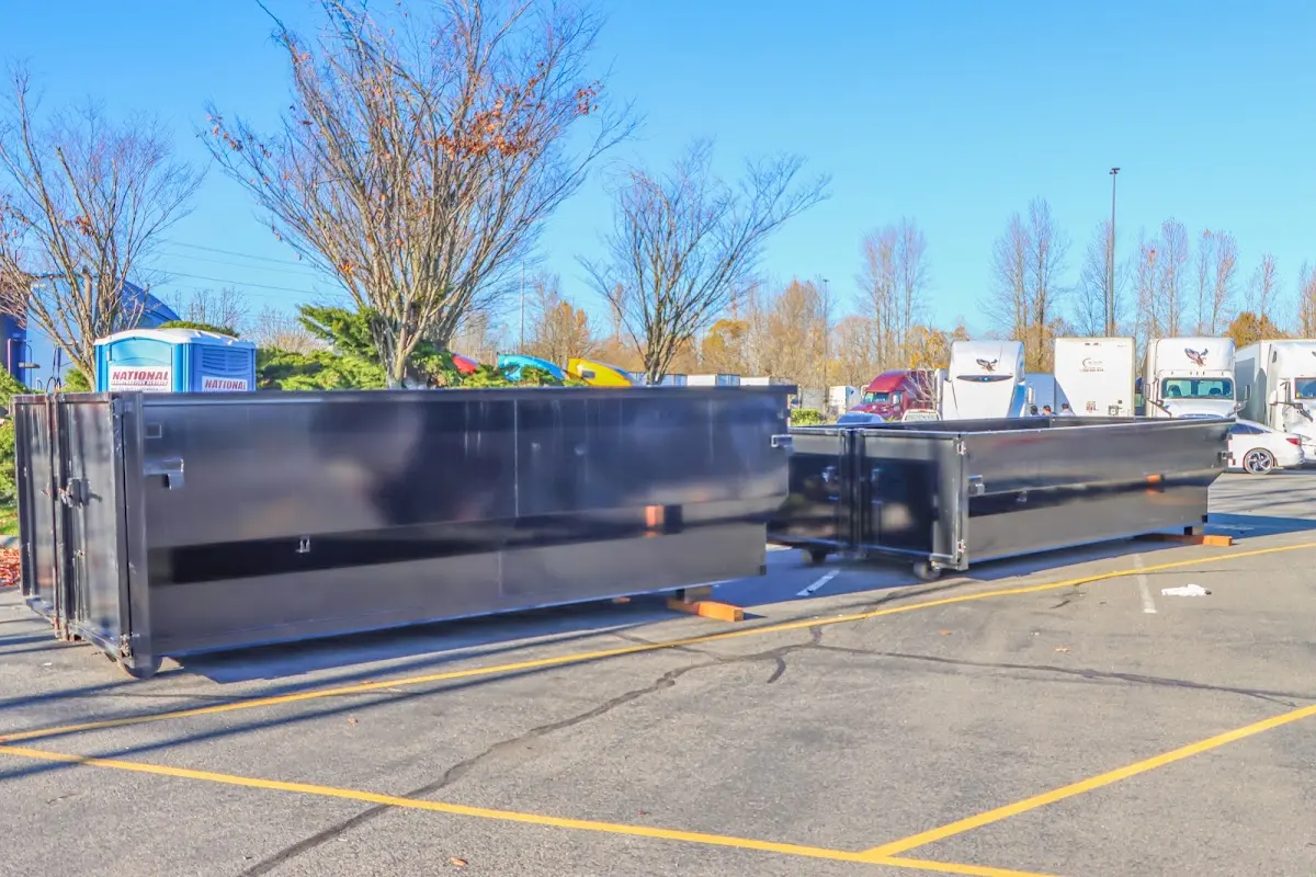 Professional dumpster rental service with roll-off container on residential driveway in Kaser